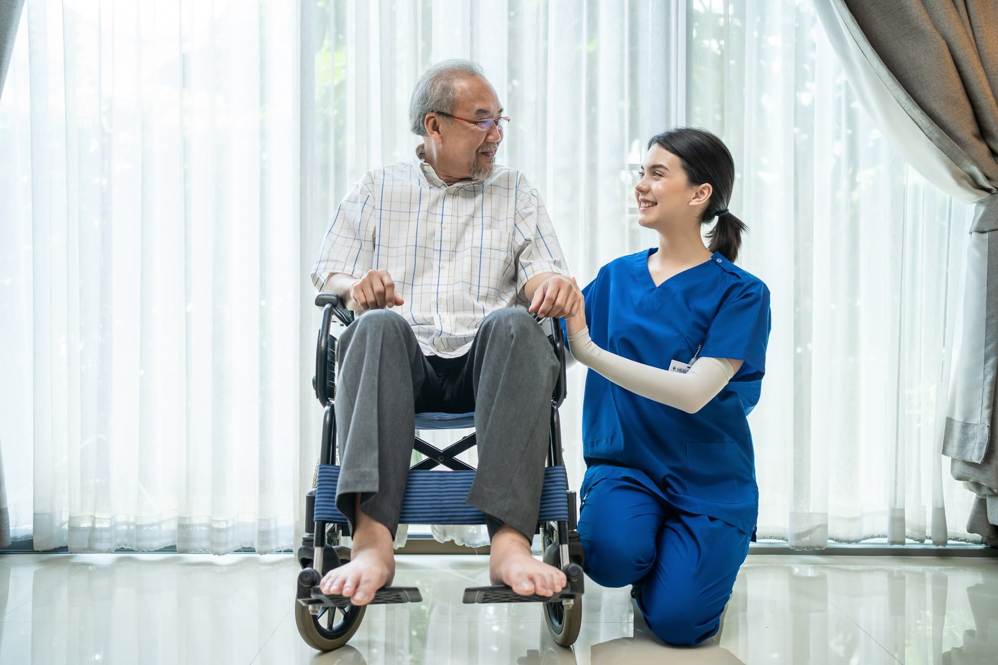 A care worker supporting an older person using a wheelchair